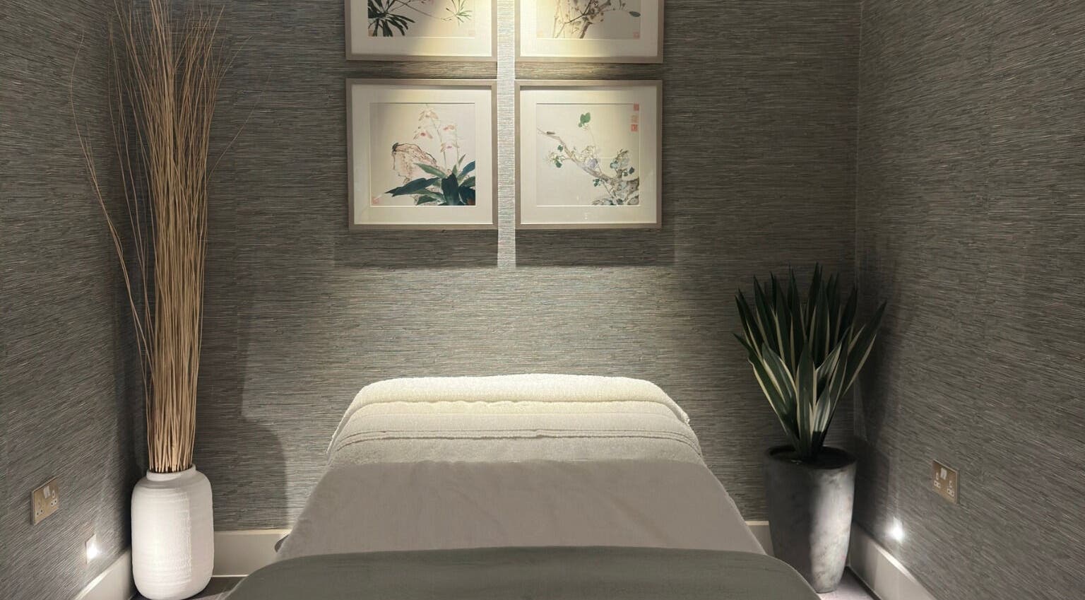 Tranquil massage room at Reflex Harmony, Cirencester, England, GB, featuring soft lighting and elegant decor.