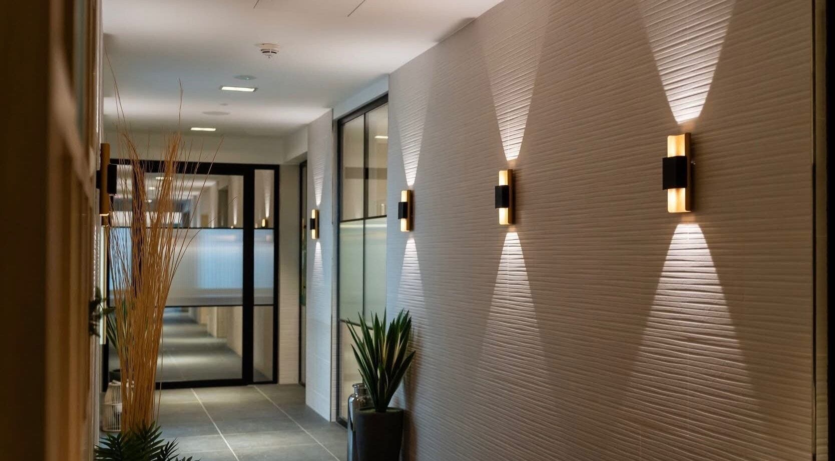 Elegant hallway at Reflex Harmony, Cirencester, England, GB, showcasing modern lighting and decor.