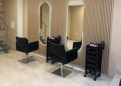 Elegant salon interior at The Beauty Lab in Ħal Qormi, MT, featuring sleek black chairs and modern decor.