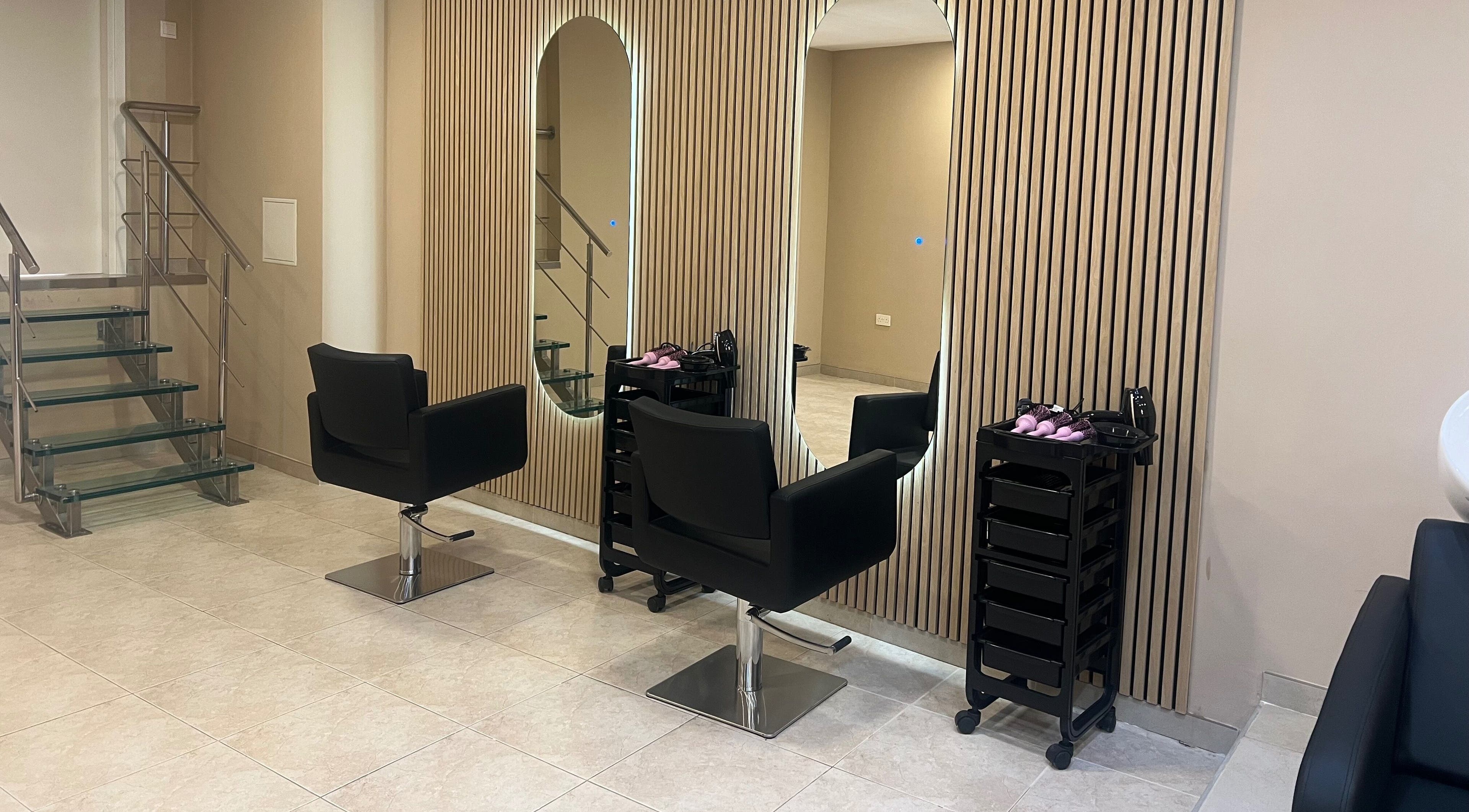 Elegant salon interior at The Beauty Lab in Ħal Qormi, MT, featuring sleek black chairs and modern decor.