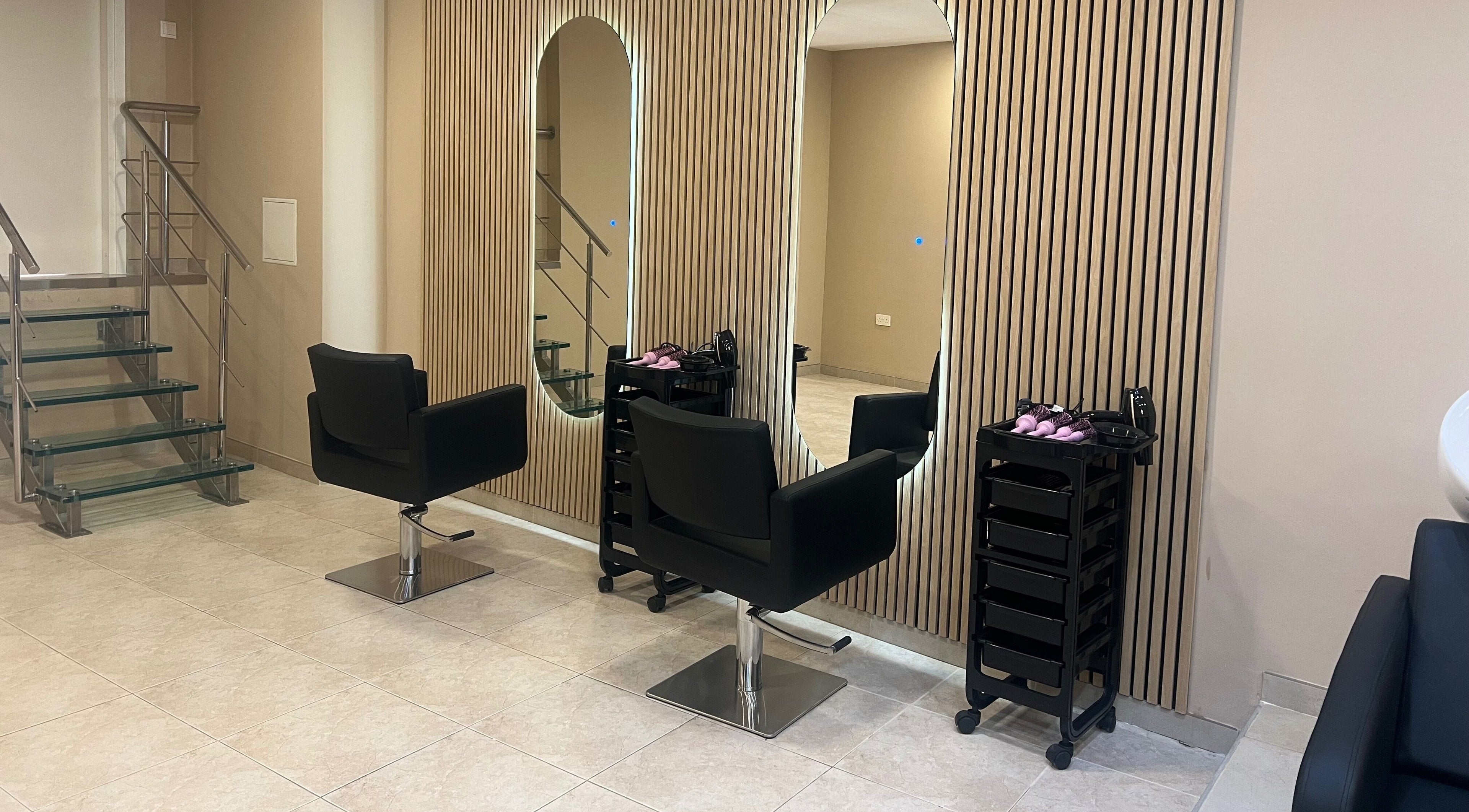 Elegant salon interior at The Beauty Lab in Ħal Qormi, MT, featuring sleek black chairs and modern decor.