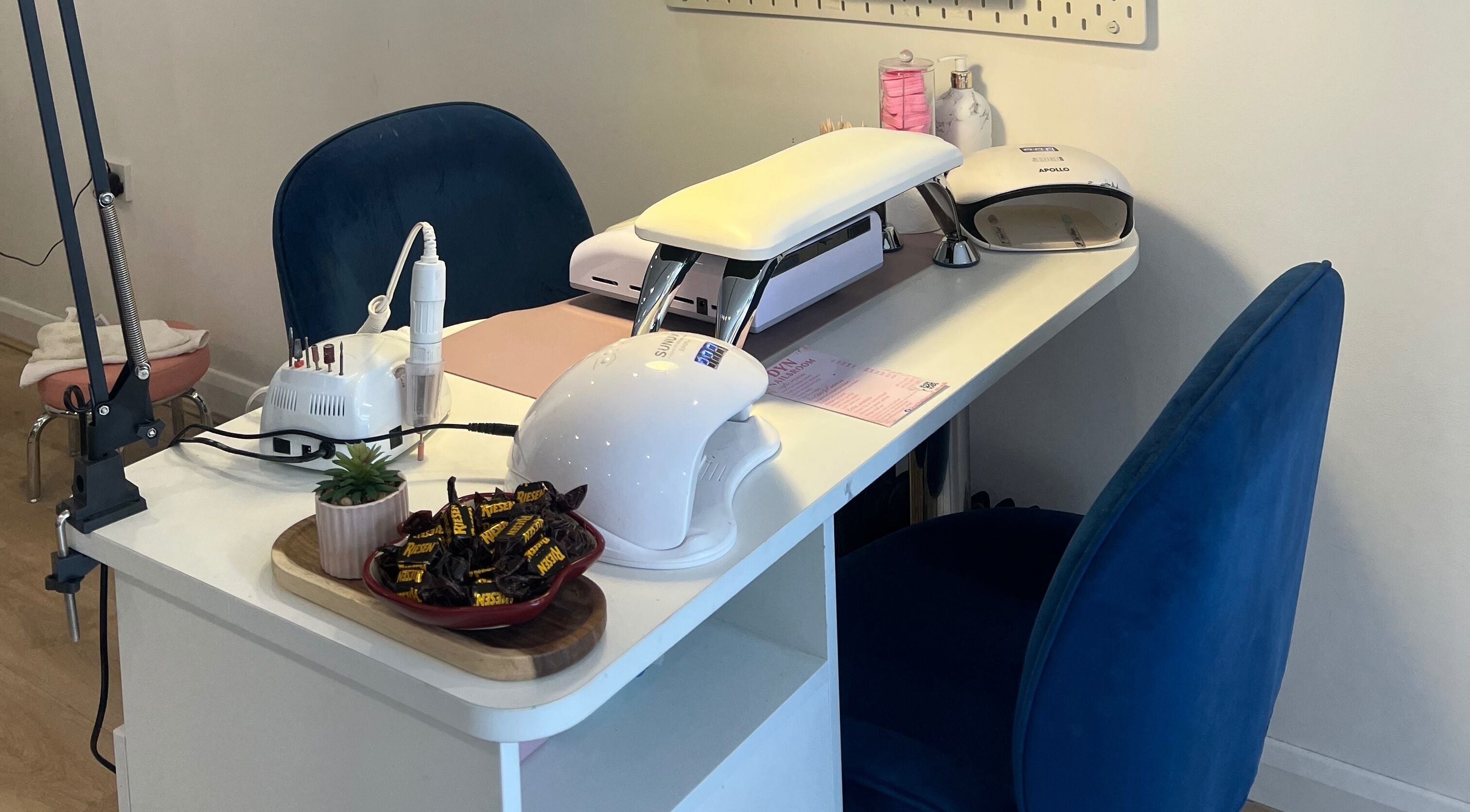 Nail station setup at DYN NAILSROOM, Mold, Wales, GB with tools and cozy seating.