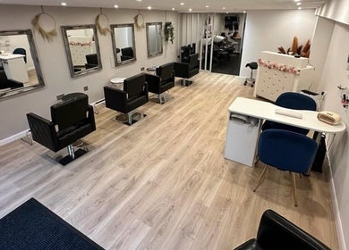 Modern interior of DYN NAILSROOM, Mold, Wales, GB, featuring stylish chairs and mirrors.