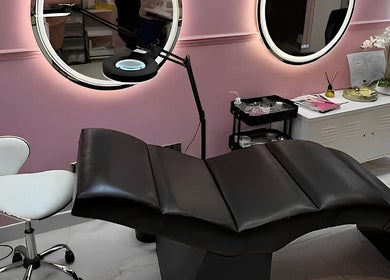 Elegant treatment room at Nicole’s Dolls House, London, England, GB with sleek black bed and pink walls.