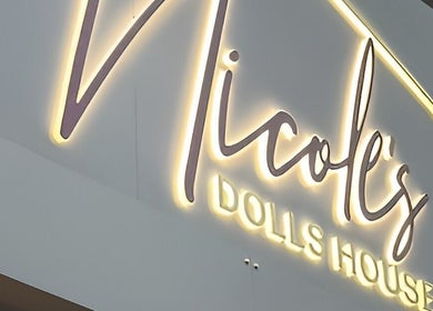 Illuminated sign of Nicole’s Dolls House in London, England, GB, showcasing elegant branding.