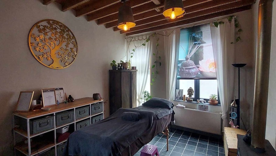 Rustieke wellnessruimte bij Heers in Vlaanderen, BE met massagebed en warme decoraties.