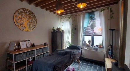 Rustieke wellnessruimte bij Heers in Vlaanderen, BE met massagebed en warme decoraties.