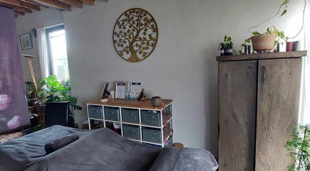 Een rustieke spa-kamer bij Heers, Vlaanderen, BE, met planten, houten kast en gouden wanddecoratie.