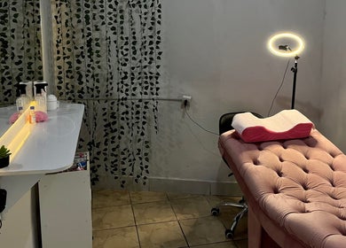 Sala de estética aconchegante em Lashes By Gio, Goiás, Goiás, BR, com cama rosa e iluminação suave.