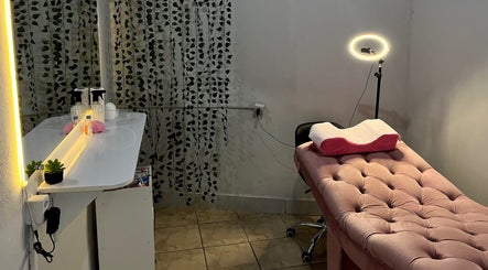 Sala de estética aconchegante em Lashes By Gio, Goiás, Goiás, BR, com cama rosa e iluminação suave.