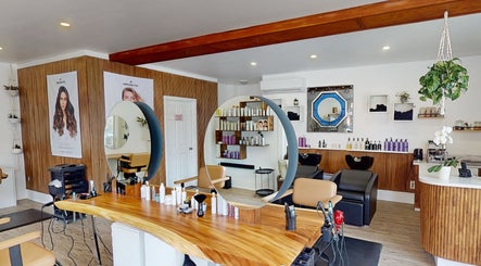 Intérieur chic du AR Salon de Coiffure à Montréal, Québec, CA, avec miroir rond et produits capillaires.