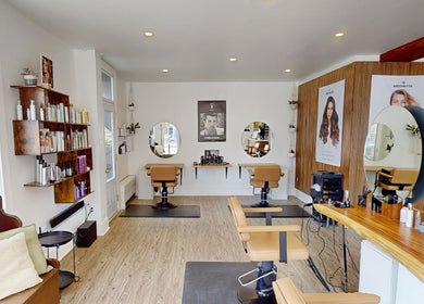 Salon moderne chez AR Salon de Coiffure à Montréal, Québec, CA, avec des sièges élégants et des miroirs ronds.