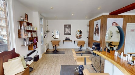 Salon moderne chez AR Salon de Coiffure à Montréal, Québec, CA, avec des sièges élégants et des miroirs ronds.