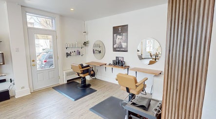 Intérieur moderne du AR Salon de Coiffure à Montréal, Québec, CA avec fauteuils et miroirs.