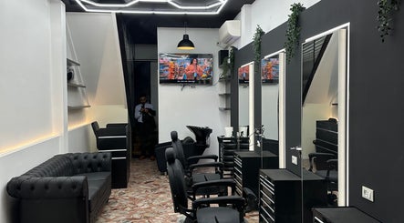 Modern interior of DEEP HAIR premium cut & shave, Romano Di Lombardia, featuring sleek chairs and decor.