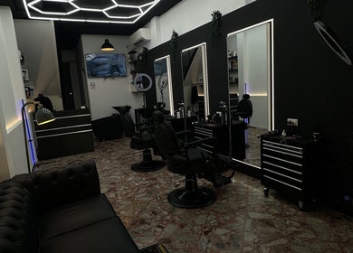 Stylish interior of DEEP HAIR premium cut & shave in Romano Di Lombardia, Lombardia, IT. Modern barbershop chairs and decor.