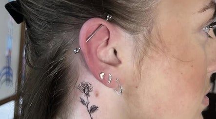 Intricate rose tattoo and multiple piercings at Liverpool Tattoos Orrell Park, Liverpool, England, GB.