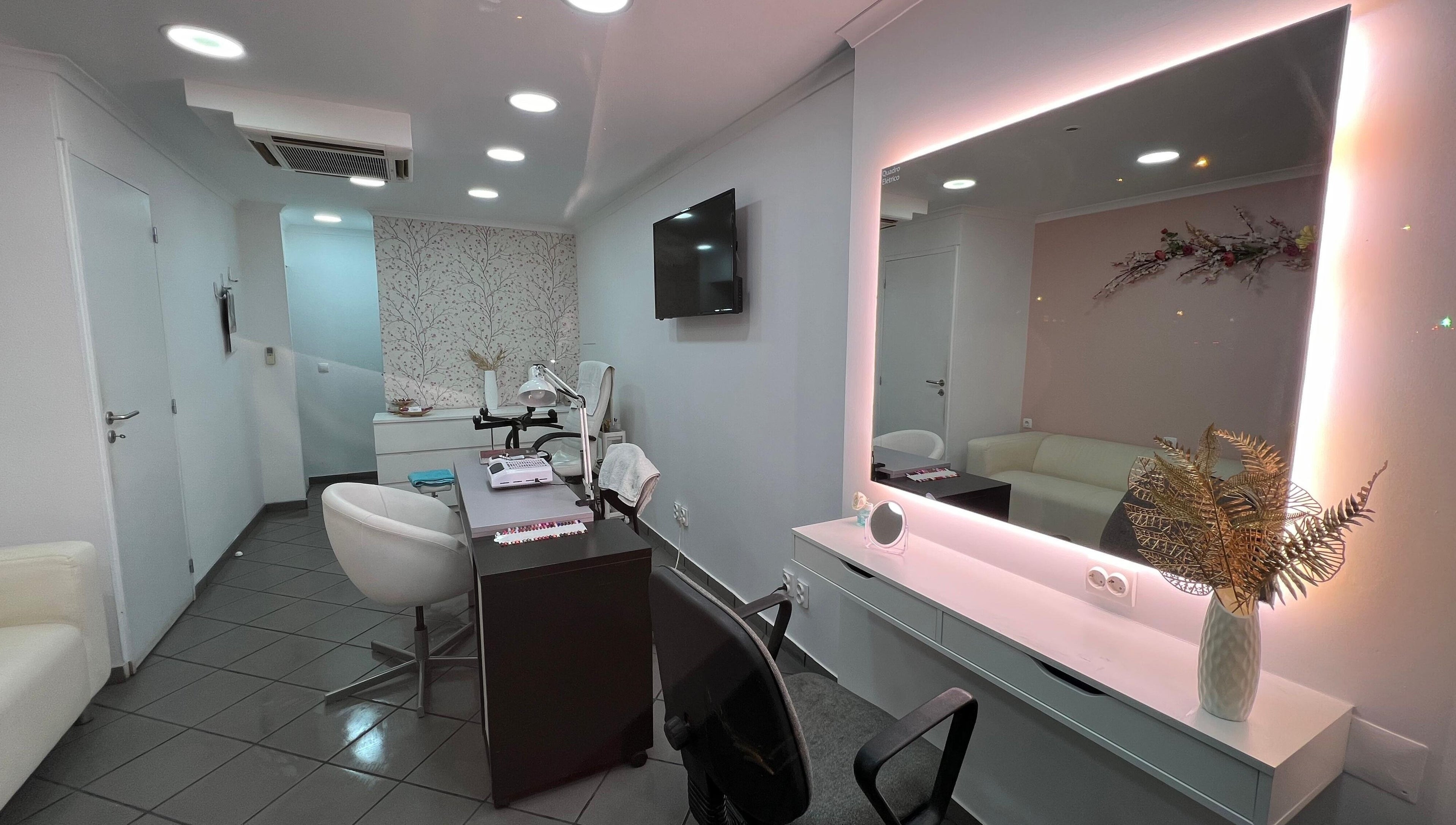 Interior sofisticado de Evabela - Espaço de Estética em Lisboa, Lisboa, PT, com espelho iluminado e mobília moderna.