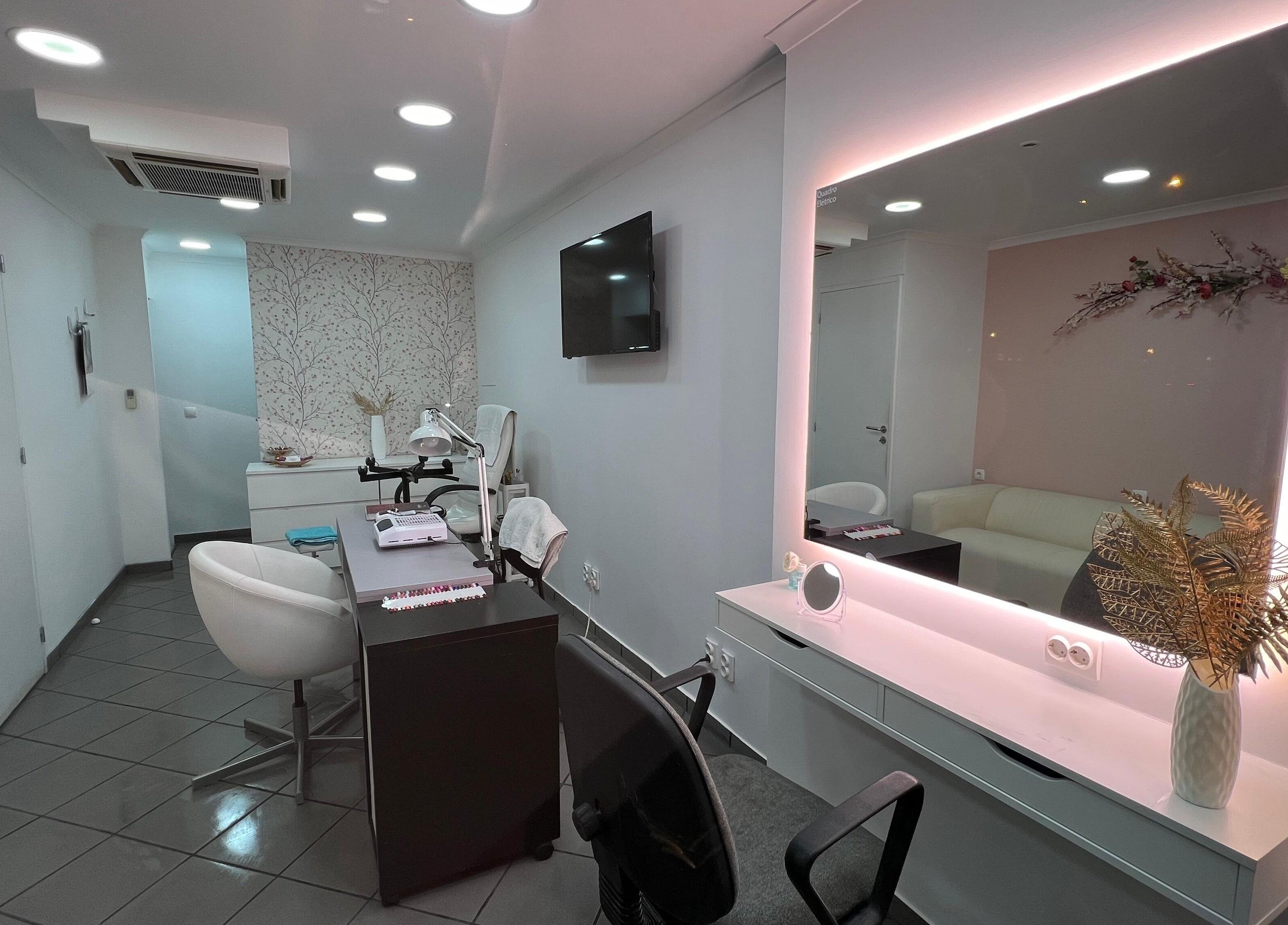 Interior sofisticado de Evabela - Espaço de Estética em Lisboa, Lisboa, PT, com espelho iluminado e mobília moderna.