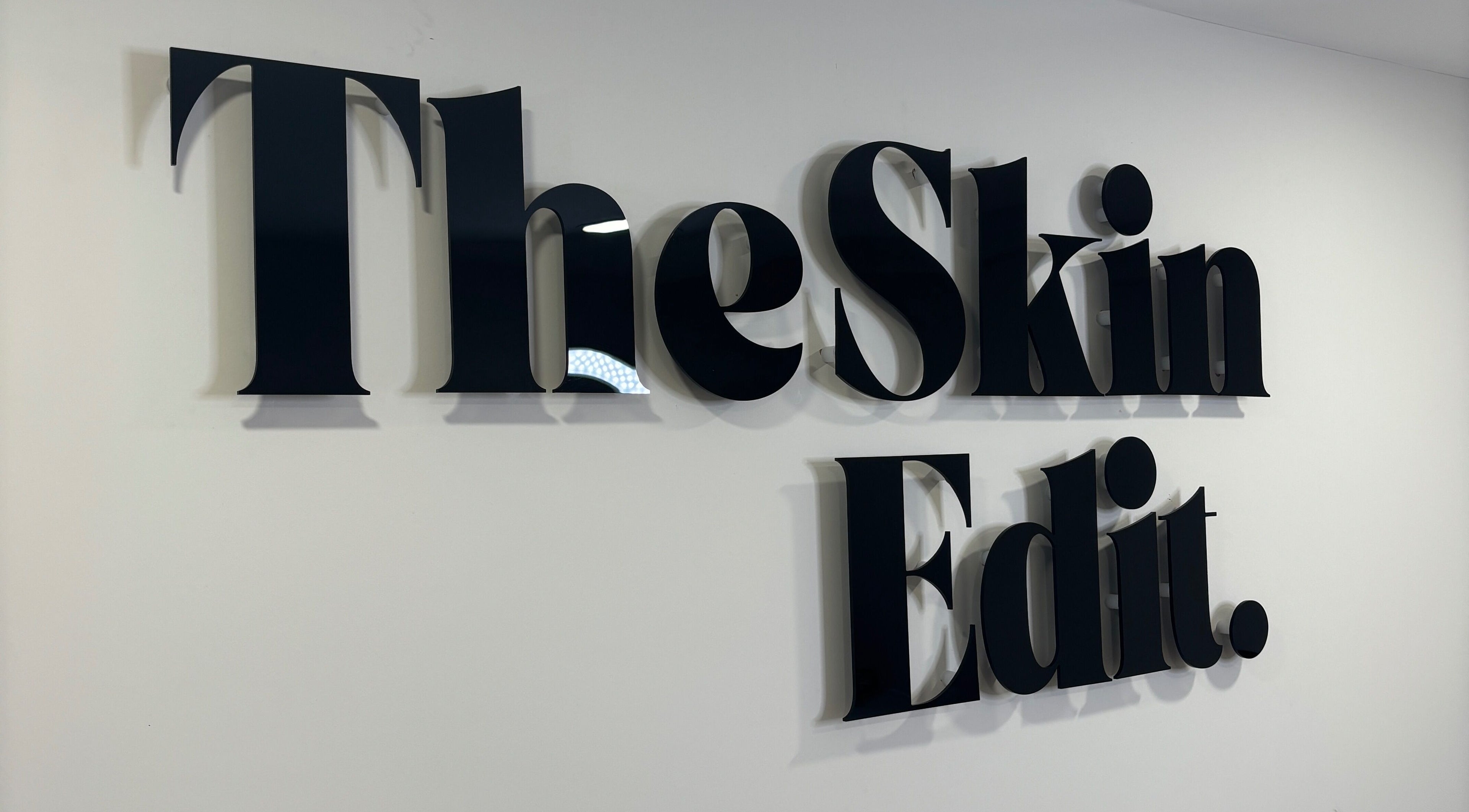 Sleek text logo of The Skin Edit on a wall in Hamilton, Scotland, GB.