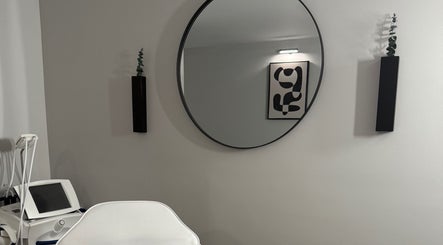 Modern spa room at RayanBeautyy - Ottawa showcasing a round mirror and contemporary decor in Ottawa, Ontario, CA.