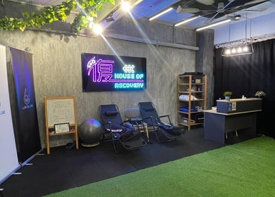 Relaxing corner at FU HOUSE RECOVERY, Kuala Lumpur featuring chairs and a neon sign.