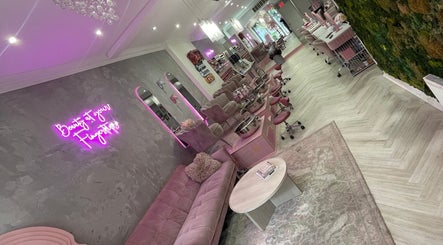 Chic interior of Top Coat in Toronto, Ontario, CA featuring plush seating and pink neon decor.