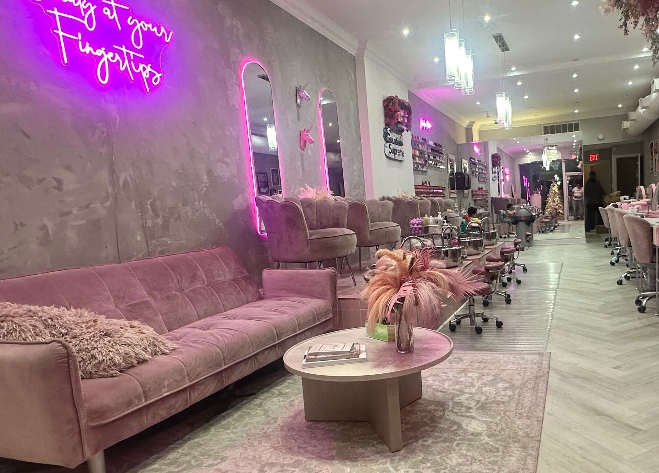 Relaxed interior of Top Coat salon in Toronto, Ontario, CA with pink couches and modern decor.