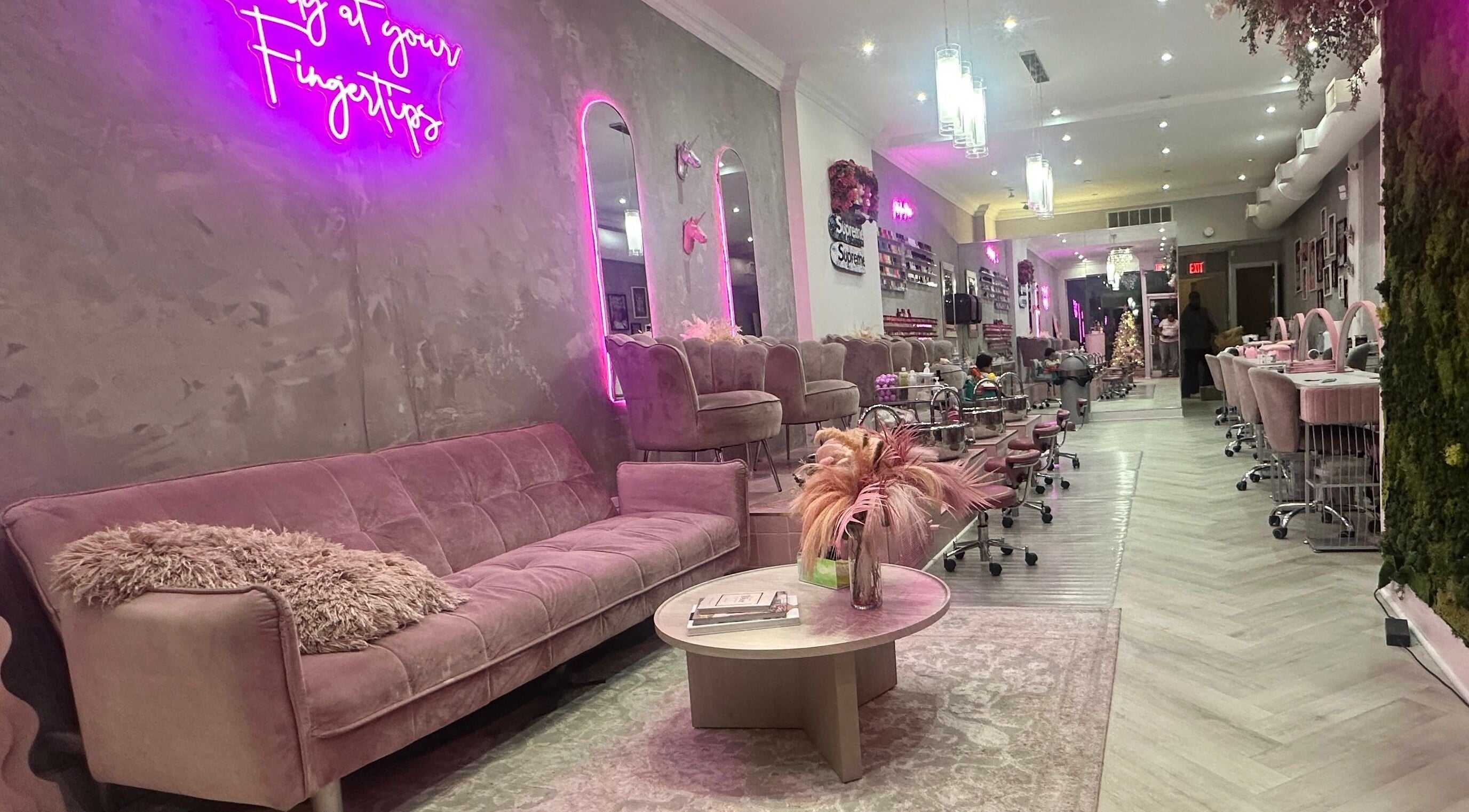 Relaxed interior of Top Coat salon in Toronto, Ontario, CA with pink couches and modern decor.