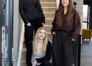 Team at Drader Brows on stairs in Auckland, NZ welcoming guests to their beauty venue.
