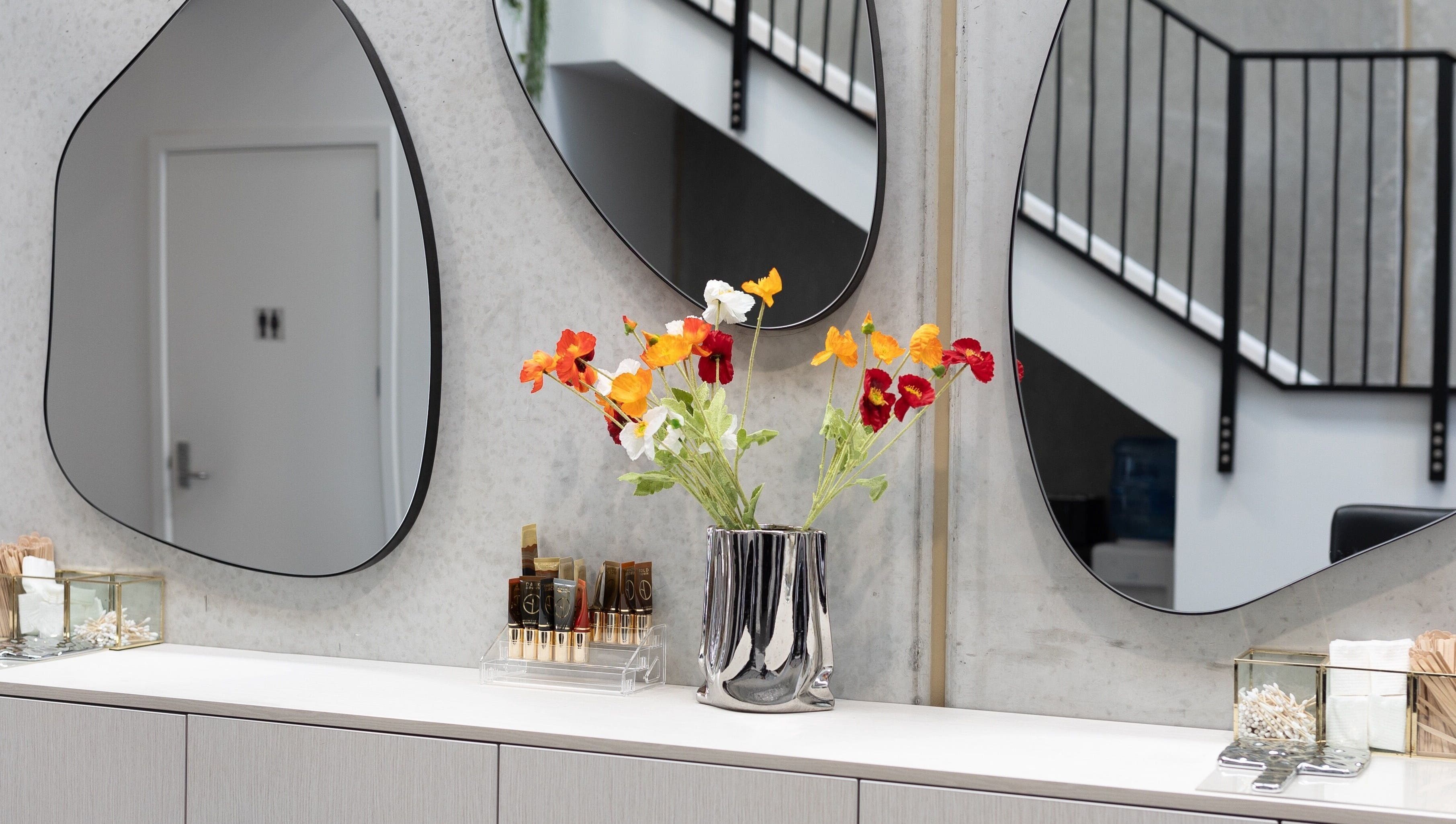 Stylish vanity with mirrors and floral decor at Drader Brows, Auckland, Auckland, NZ.