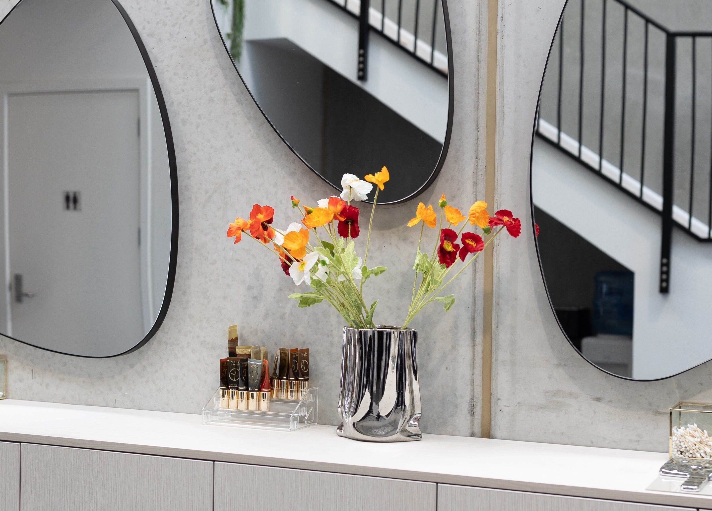 Stylish vanity with mirrors and floral decor at Drader Brows, Auckland, Auckland, NZ.