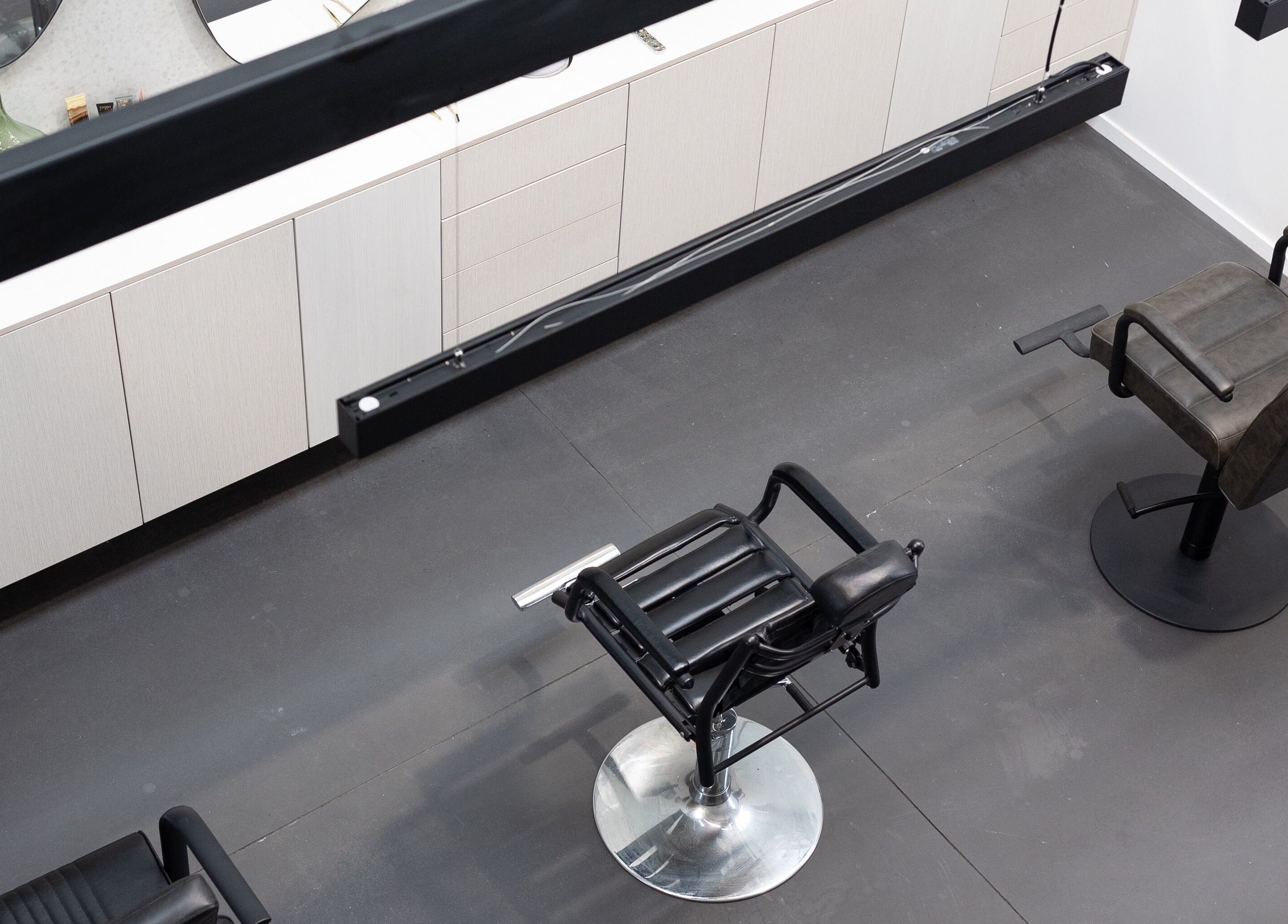 Modern salon interior at Drader Brows in Auckland, Auckland, NZ with stylish chairs and sleek cabinets.