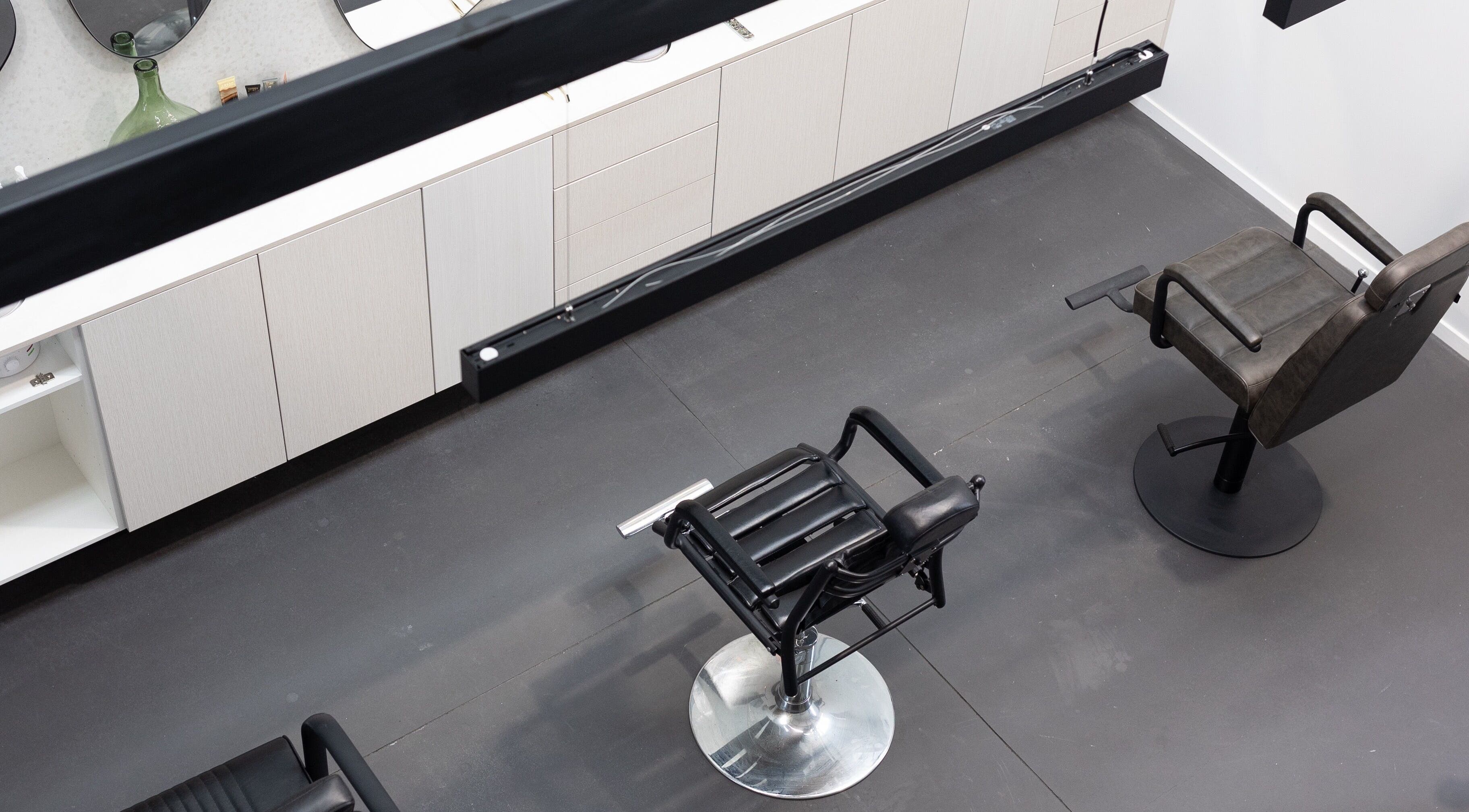 Modern salon interior at Drader Brows in Auckland, Auckland, NZ with stylish chairs and sleek cabinets.