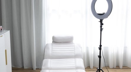 Elegant treatment room at Drader Brows in Auckland, Auckland, NZ, featuring a plush white spa bed and ring light.