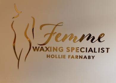 Femme Waxing Specialist Hollie Farnaby logo in Leeds, England, GB with elegant gold lettering on a light wall.