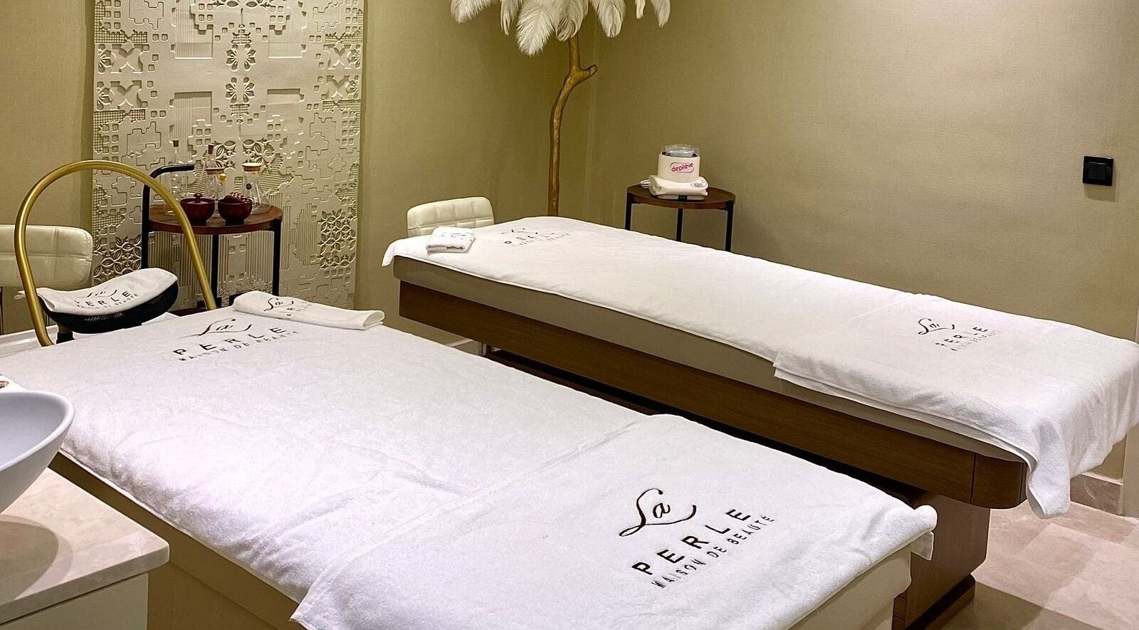 Salle de massage élégante à La Perle Maison de Beauté, Casablanca, Maroc, MA avec lits de soins et décor apaisant.
