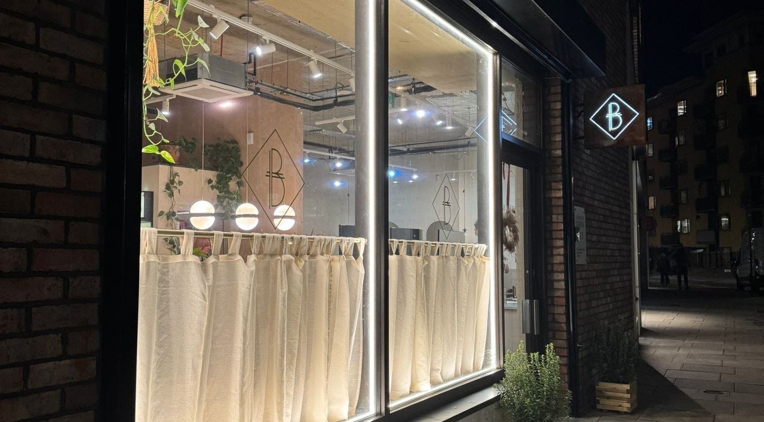 The Holistic Project's illuminated exterior at night in London, England, GB showcasing modern elegance.