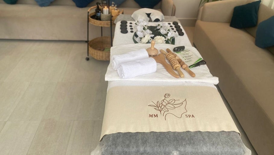 Relaxing setup at MMSPA - Home Service, Riyadh, SA, featuring massage tools and towels on treatment table.