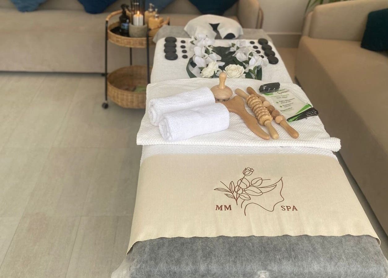 Luxurious spa setup at MMSPA - Home Service in Riyadh, SA, showcasing towels, wooden tools, and decor.