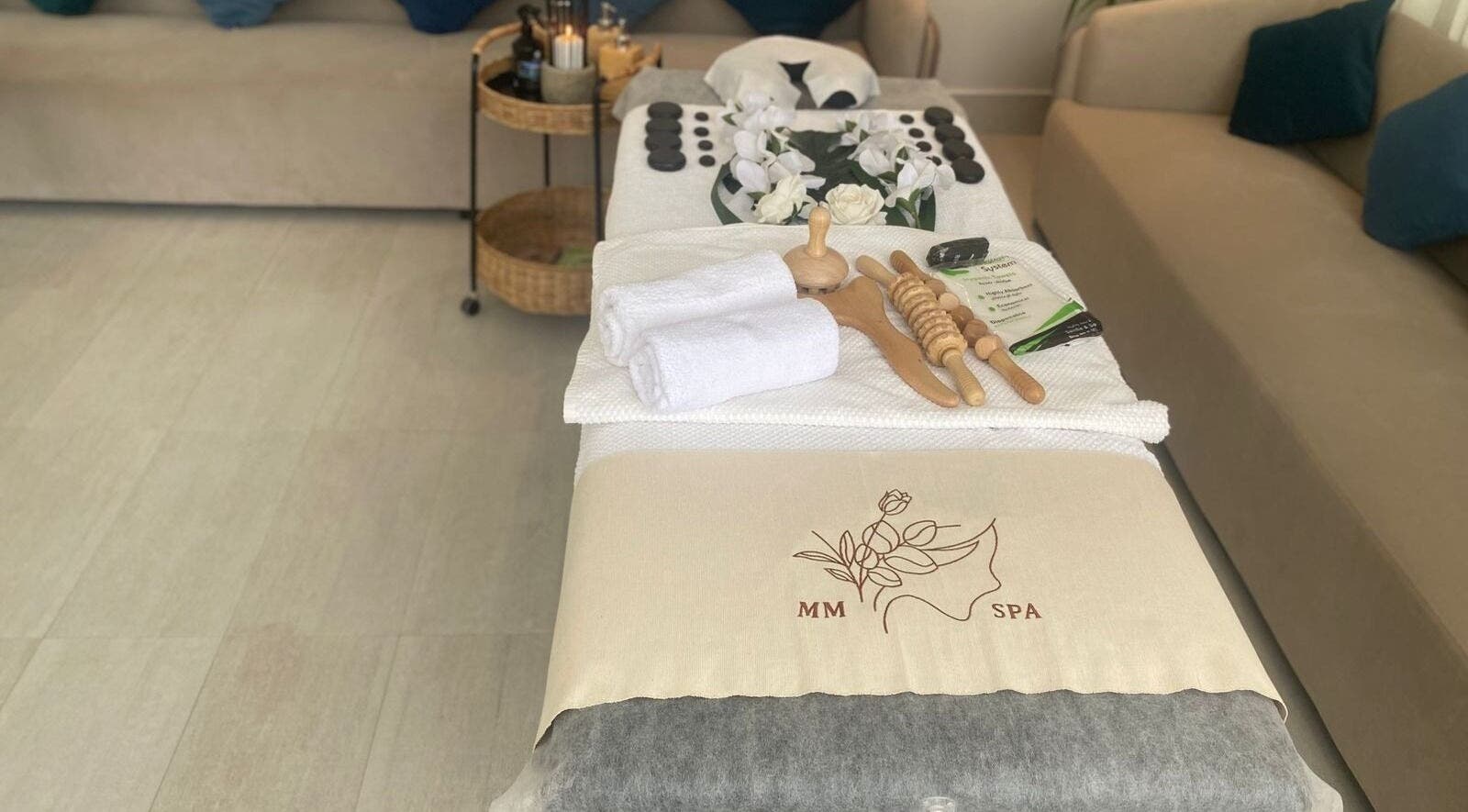 Luxurious spa setup at MMSPA - Home Service in Riyadh, SA, showcasing towels, wooden tools, and decor.