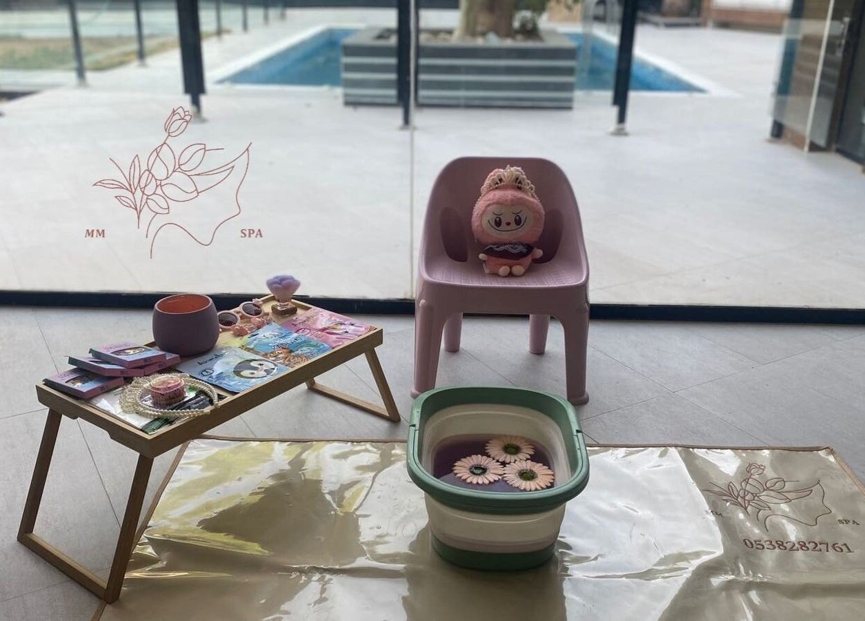 Cozy spa setup at MMSPA - Home Service, Riyadh, SA, featuring a plush chair and relaxation items.