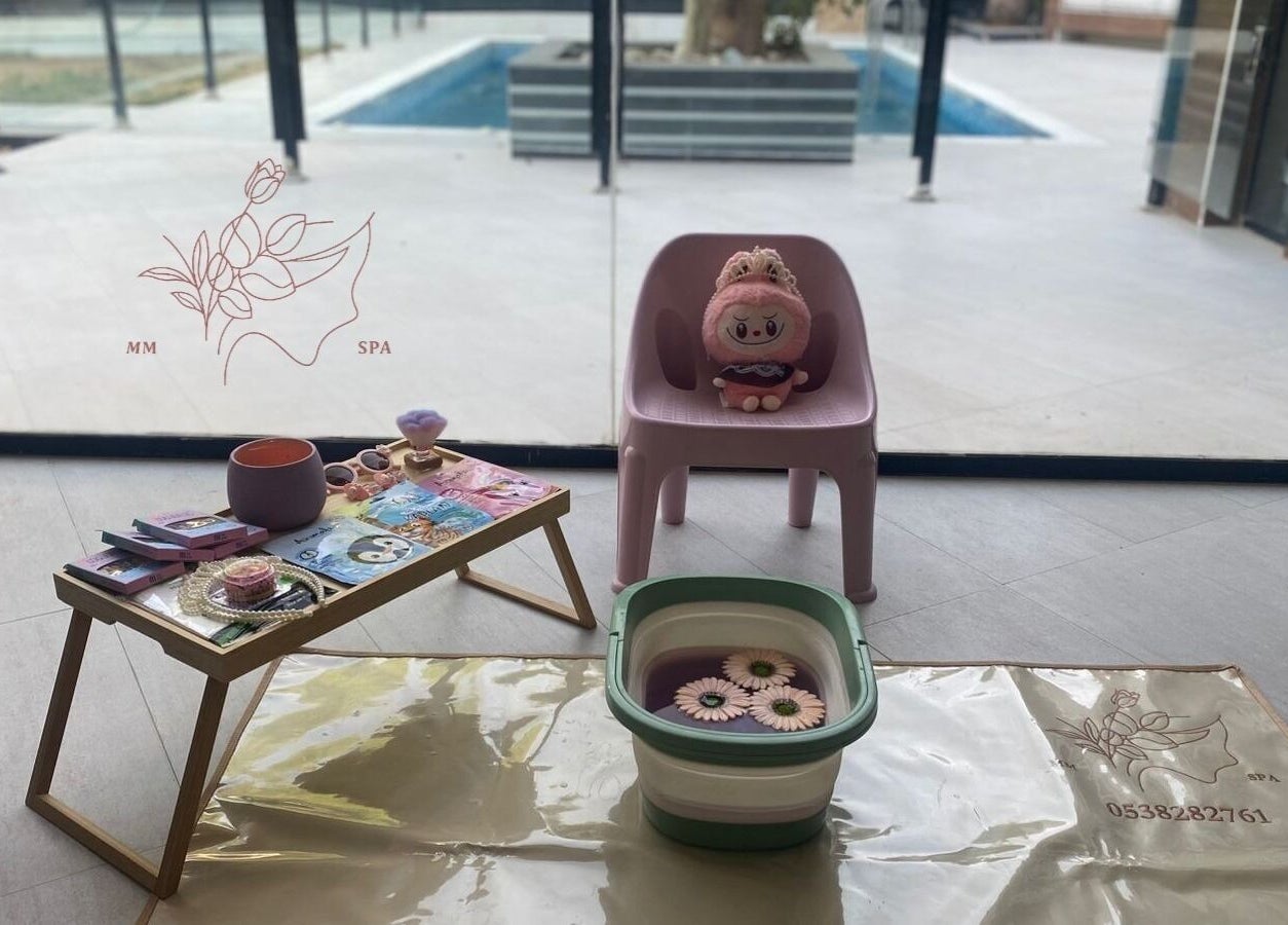 Cozy spa setup at MMSPA - Home Service, Riyadh, SA, featuring a plush chair and relaxation items.