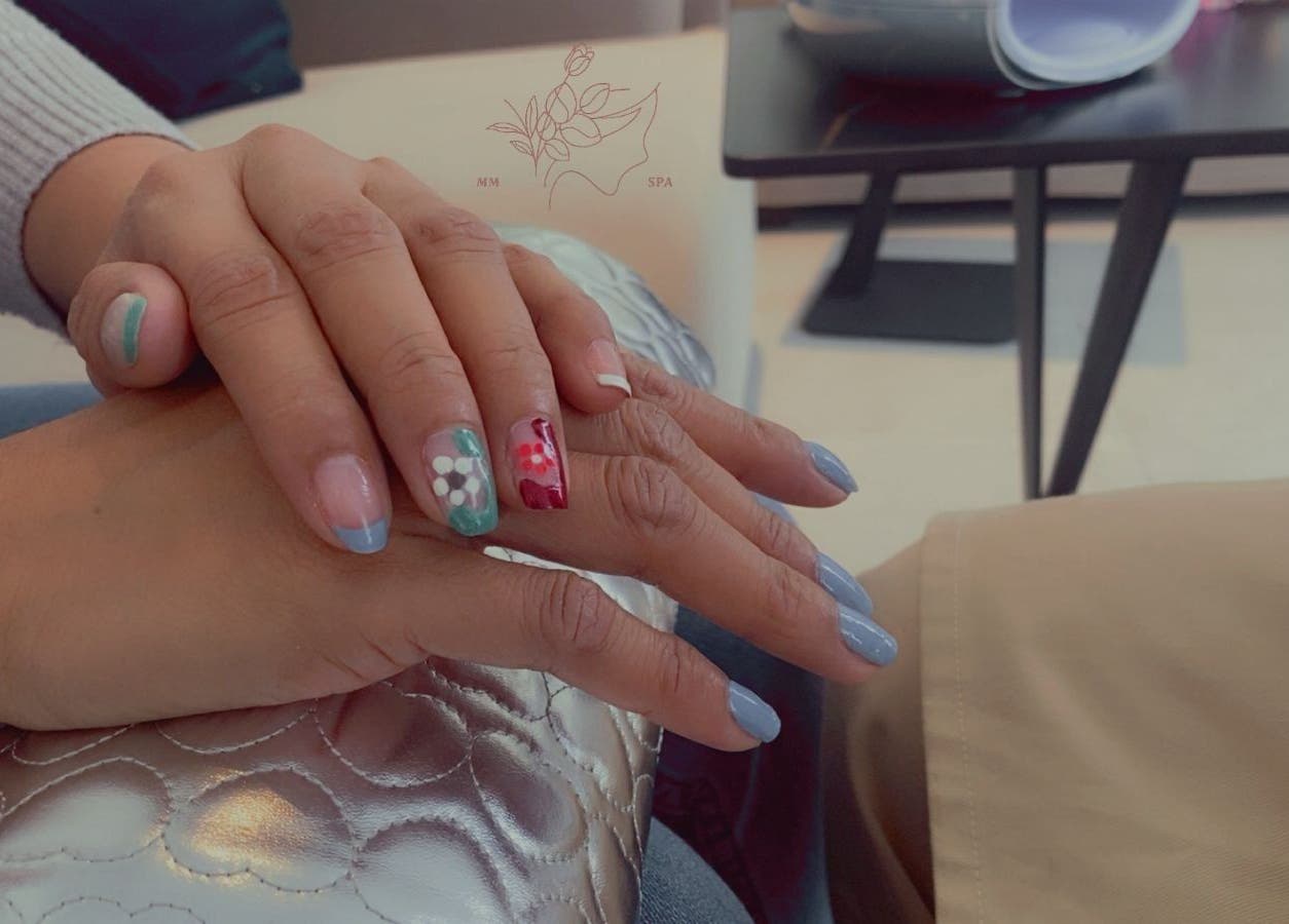 Stylish nail art with floral designs at MMSPA - Home Service in Riyadh, SA, offering elegant manicures.