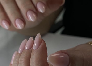 Manicura impecable en Amara Beauty Lounge, Miami, Florida, US, con uñas brillantes en tonos rosados.
