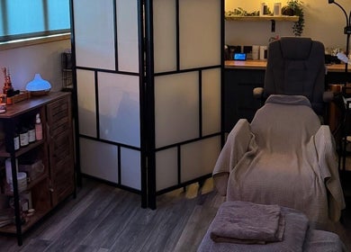 Relaxing treatment room at Bow-tiful, Hoyland, England, GB with a cozy chair and tranquil lighting.