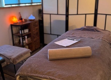 Tranquil massage room at Bow-tiful, Hoyland, England, GB, featuring a cozy treatment bed and ambient lighting.