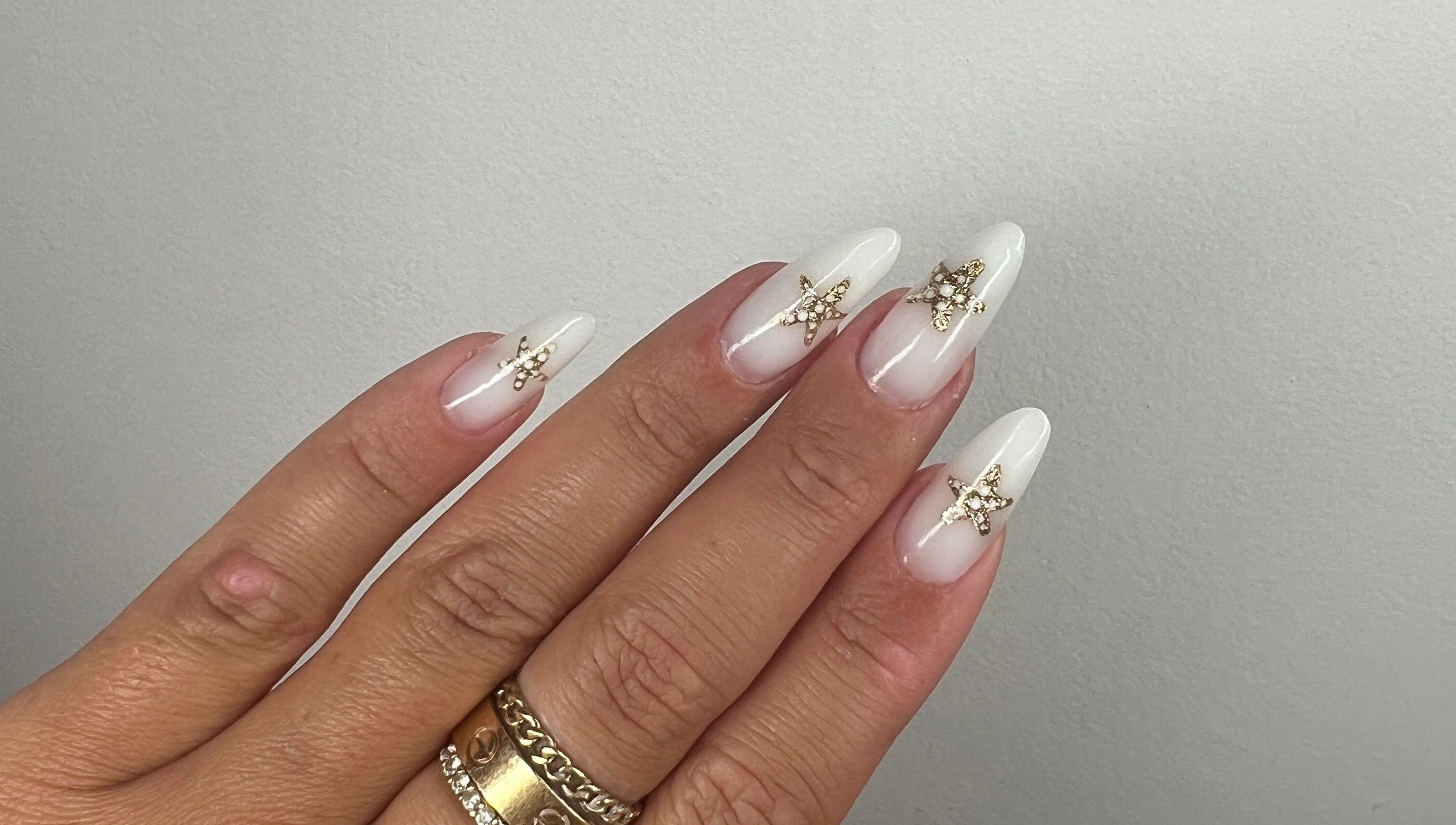 Elegant gold-embellished white nails at Aurora Beauty by Drea, San Pawl il-Baħar, MT.