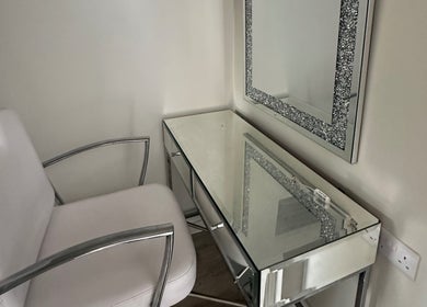 Chic makeup station at Amelia Rose Studio in Bracknell, England, GB with elegant mirrored desk and comfy chair.