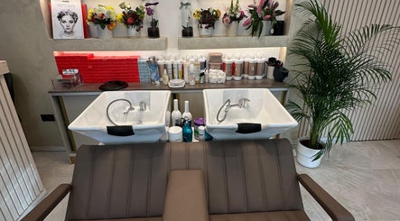 Elegant wash stations at Roza Hair Saloon in London, England, GB, surrounded by lush plants and beauty products.